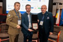 zdjęcie trzech osób podczas konferencji m.in. prof. Roberta Gałązkowskiego 